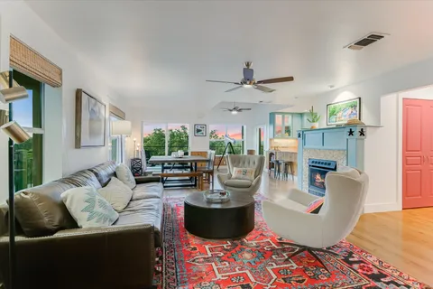 a living room with fireplace furniture and a large window