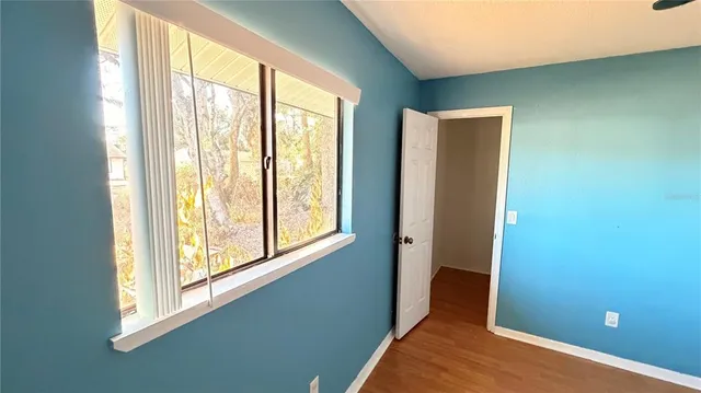 a view of wooden house with a yard and large tree