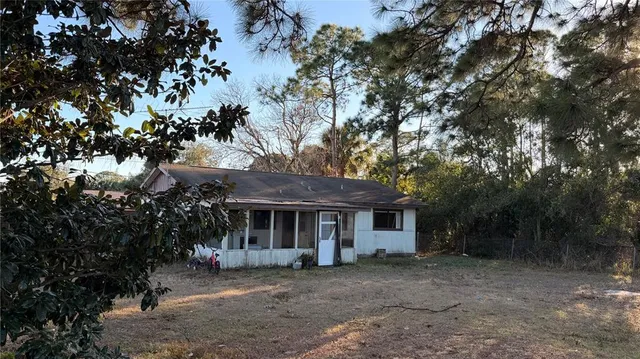 a view of a house with a large window and wooden fence