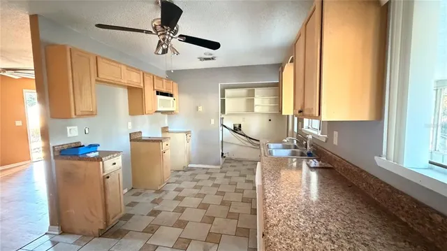 a kitchen with stainless steel appliances a stove a sink cabinets and a window