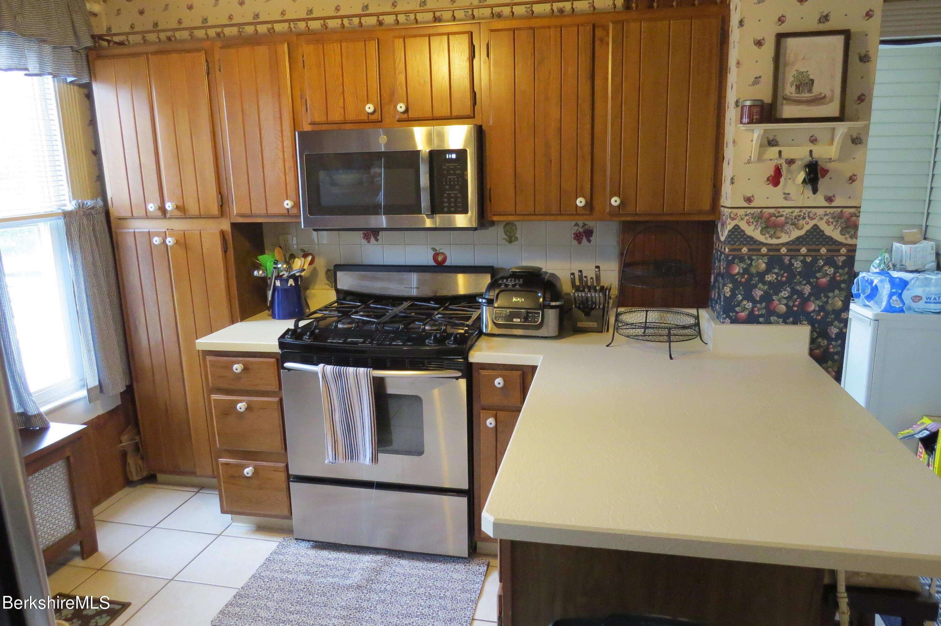 29 Crandall Street Adams, MA 01220 - Photo 19 of 61 a kitchen with stainless steel appliances a stove a microwave a sink and cabinets