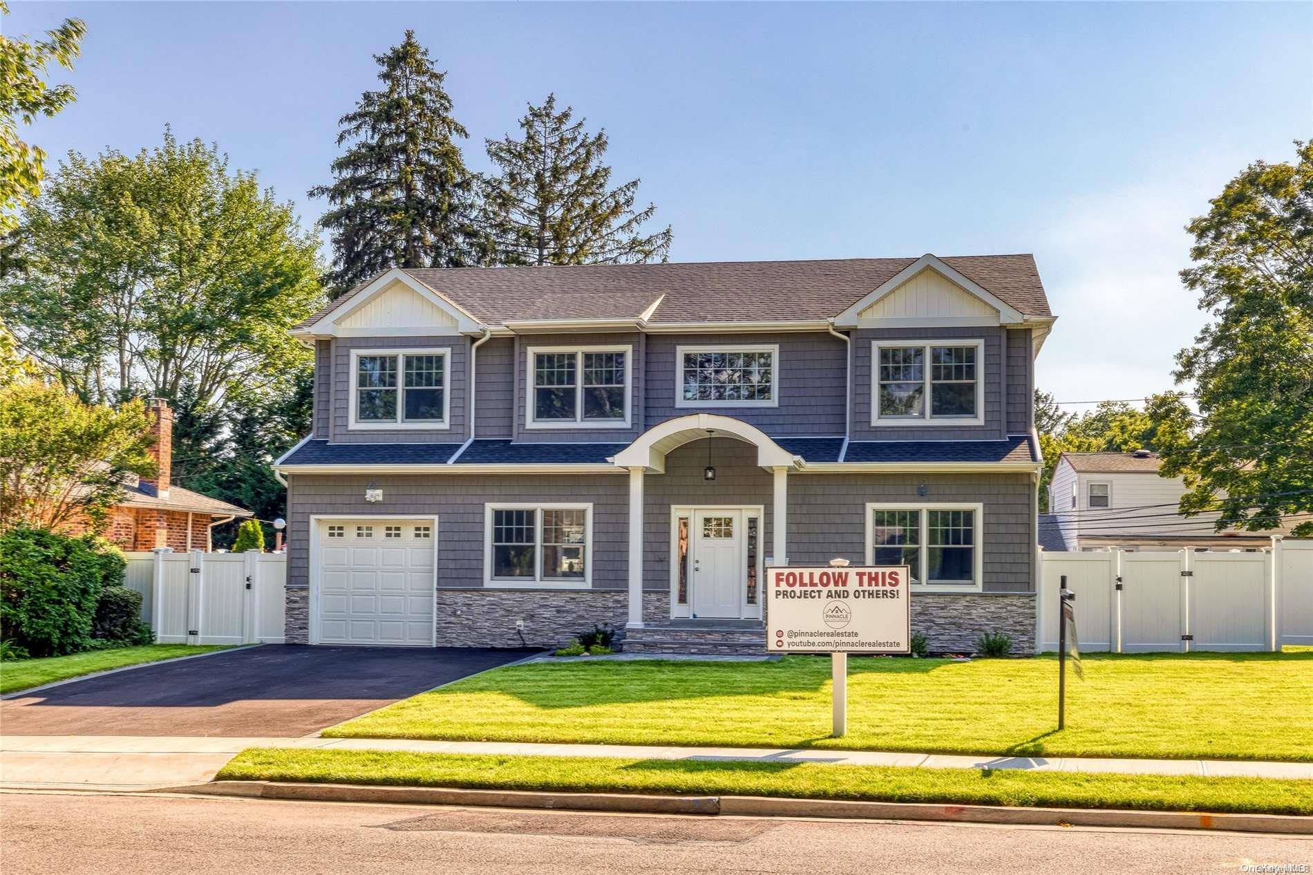 a front view of a house with swimming pool and glass windows and yard