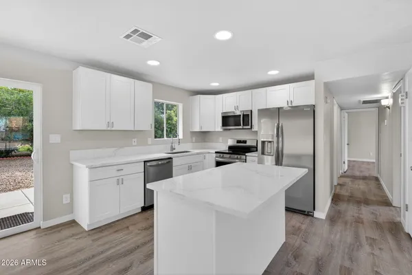 a kitchen with white cabinets and stainless steel appliances