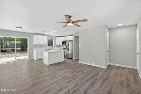 a view of a kitchen with wooden floor and a ceiling fan