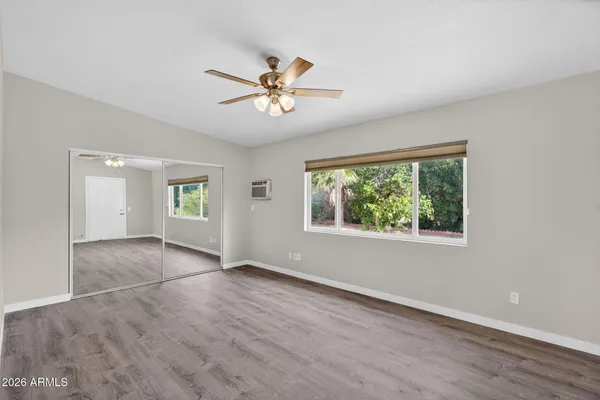 a view of an empty room with a window and wooden floor