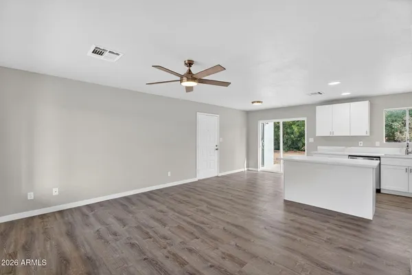 a view of a kitchen with a sink a ceiling fan and refrigerator
