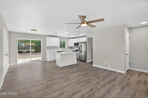 a view of a big room with wooden floor and windows