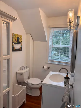 a bathroom with a sink and mirror with toilet