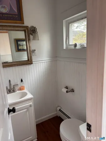 a bathroom with a toilet sink and mirror