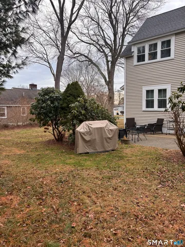 a backyard of a house with table and chairs