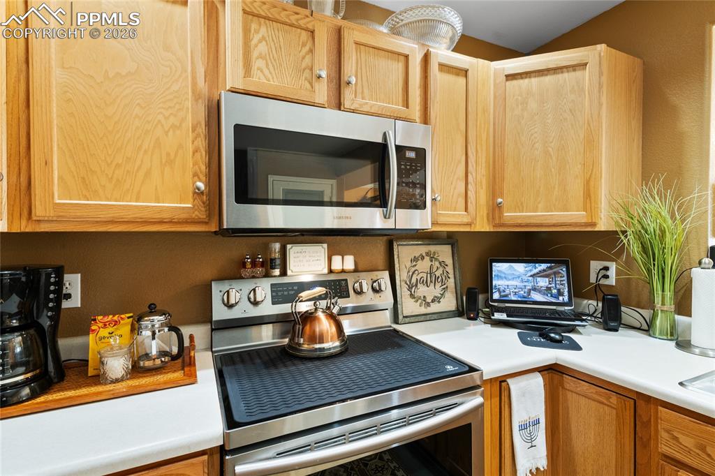 5639 Sunshade Point Colorado Springs, CO 80923 - Photo 13 of 36 a kitchen with stainless steel appliances granite countertop a stove a microwave and cabinets