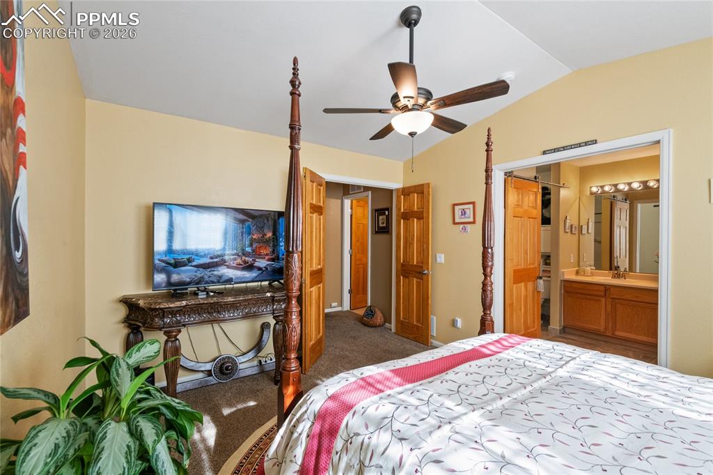 5639 Sunshade Point Colorado Springs, CO 80923 - Photo 18 of 36 a bedroom with a bed dresser and a flat tv screen