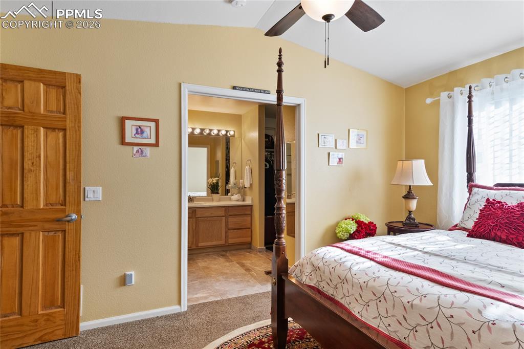 5639 Sunshade Point Colorado Springs, CO 80923 - Photo 19 of 36 a bedroom with a bed and a chandelier