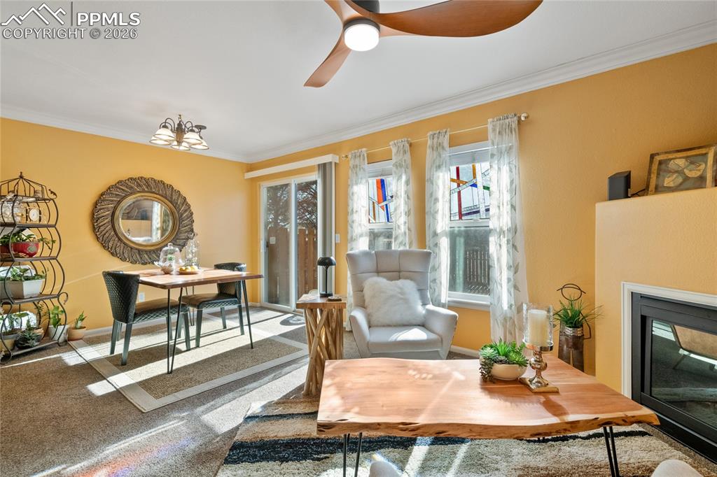 5639 Sunshade Point Colorado Springs, CO 80923 - Photo 8 of 36 a living room with fireplace furniture and a large window