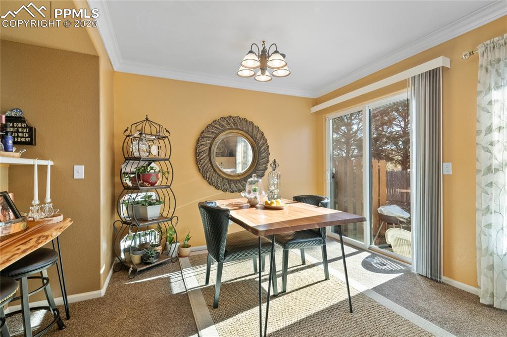 5639 Sunshade Point Colorado Springs, CO 80923 - Photo 9 of 36 a view of a dining room with furniture and chandelier