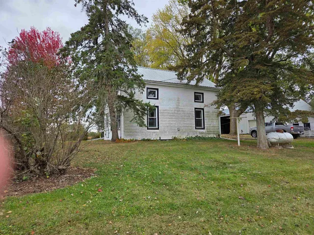 a backyard of a house with table and chairs