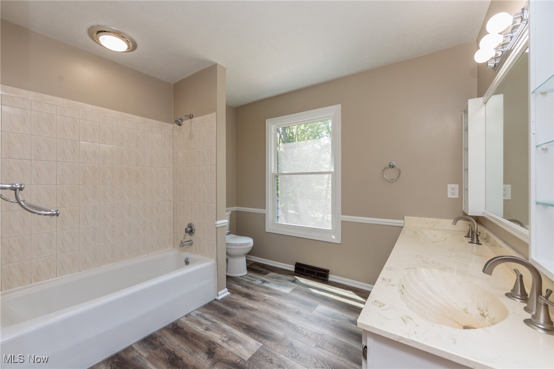 13655 Sperry Road Novelty, OH 44072 - Photo 17 of 32 Bathroom with tub / shower combination, dark wood-type flooring, and double vanity
