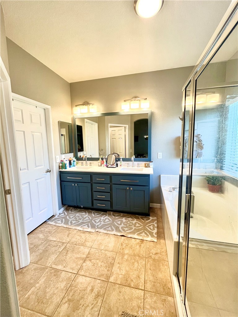 36768 Pomerol Loop Winchester, CA 92596 - Photo 14 of 31 a bathroom with a tub sink and mirror