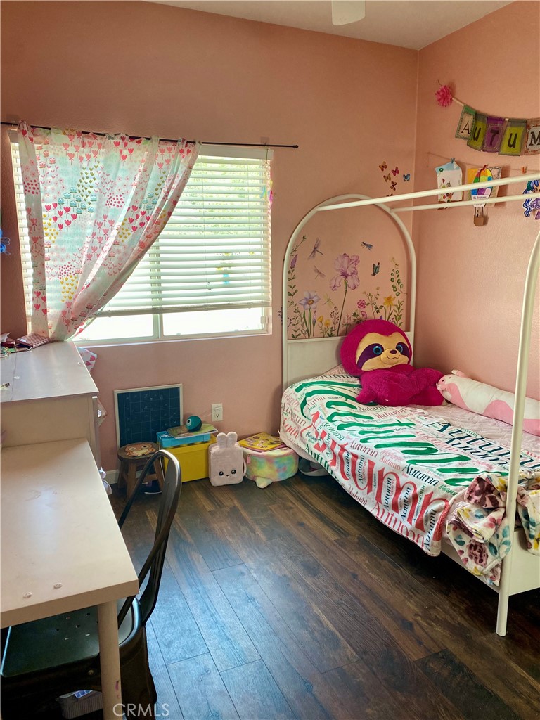 36768 Pomerol Loop Winchester, CA 92596 - Photo 17 of 31 a bedroom with a bed and a wooden floor