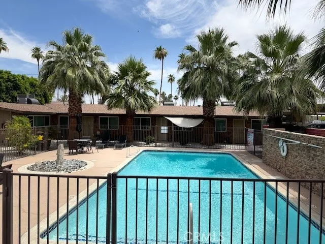 a view of a backyard patio with swimming pool and furniture