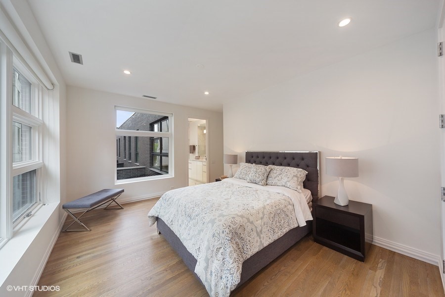 1011 North Dearborn Street Chicago, IL 60610 - Photo 20 of 33 a spacious bedroom with a bed and a wooden floor