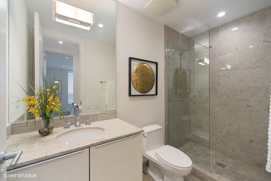1011 North Dearborn Street Chicago, IL 60610 - Photo 25 of 33 a bathroom with a granite countertop sink a toilet a mirror and shower