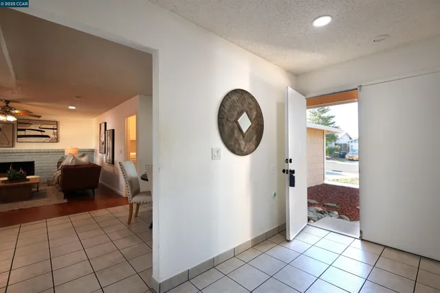 a view of a hallway with a livingroom and a bathroom