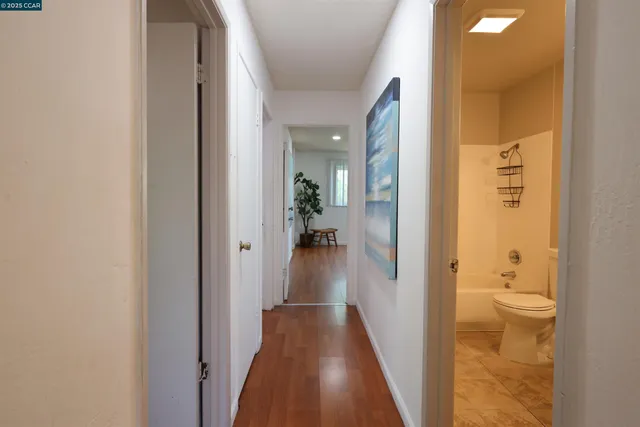 a view of a hallway with wooden floor and staircase