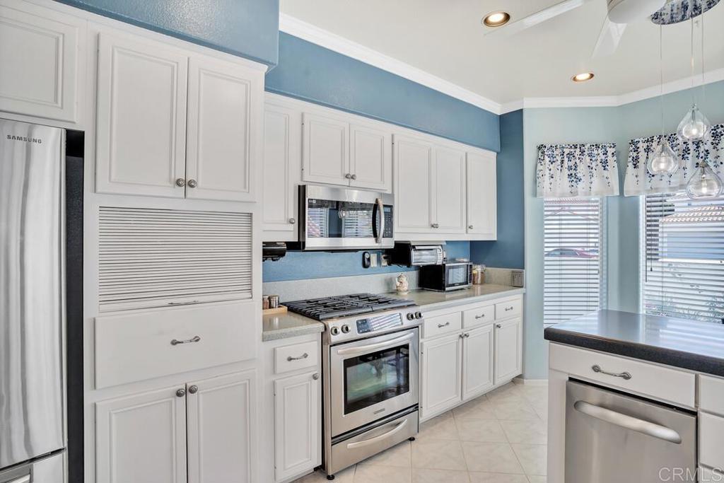 4617 Cyrus Way Oceanside, CA 92056 - Photo 7 of 63 a kitchen with granite countertop white cabinets and white appliances