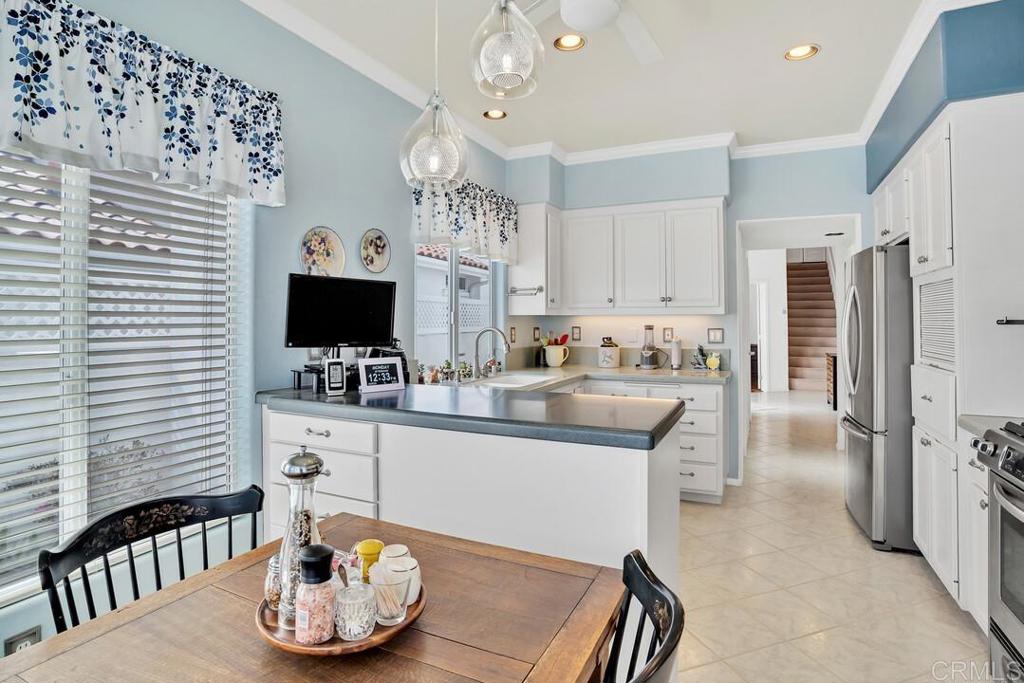 4617 Cyrus Way Oceanside, CA 92056 - Photo 9 of 63 a kitchen with stainless steel appliances kitchen island granite countertop a table and chairs in it