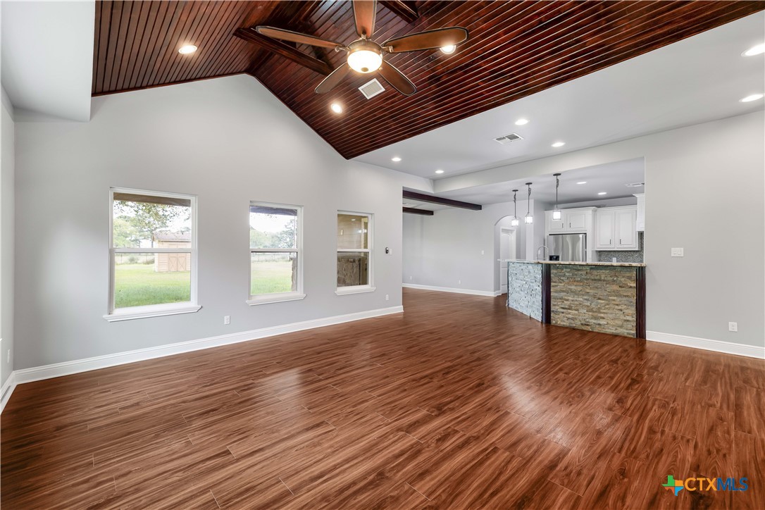 204 James Street Inez, TX 77968 - Photo 7 of 35 a view of an empty room with wooden floor and a kitchen