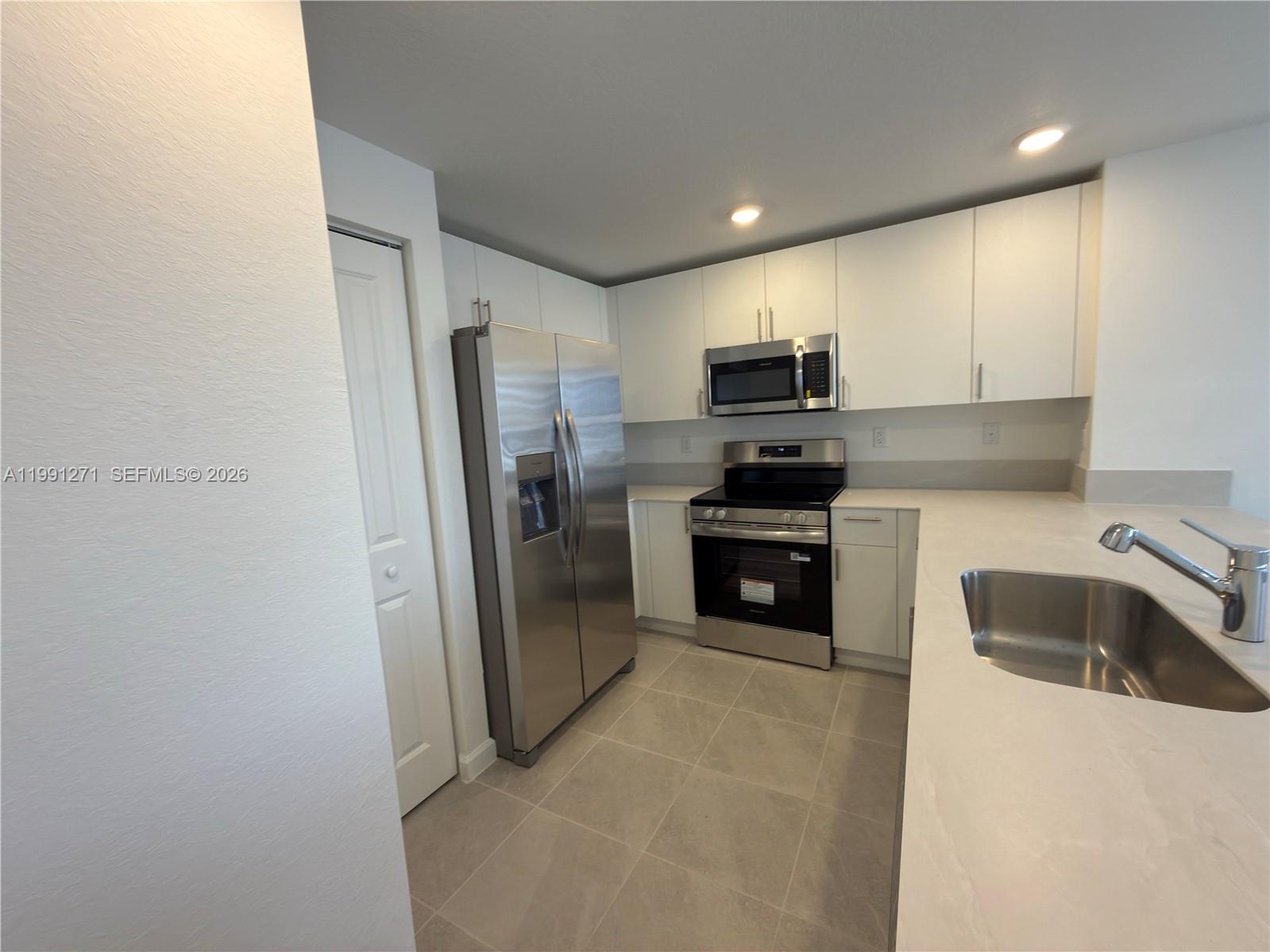 12426 Southwest 248th Street, Unit 1 Homestead, FL 33032 - Photo 6 of 13 a kitchen with a refrigerator and a sink