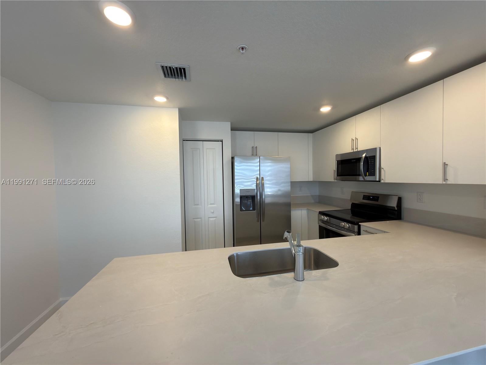 12426 Southwest 248th Street, Unit 1 Homestead, FL 33032 - Photo 7 of 13 a kitchen with stainless steel appliances a refrigerator and microwave