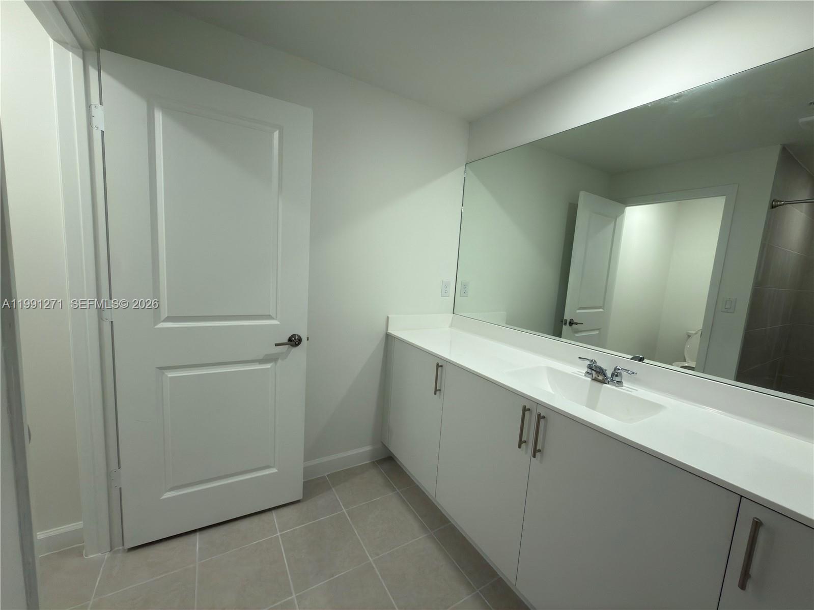12426 Southwest 248th Street, Unit 1 Homestead, FL 33032 - Photo 9 of 13 a bathroom with a double vanity sink and mirror