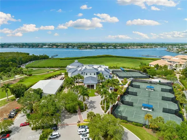 an aerial view of a residential houses with outdoor space and ocean view