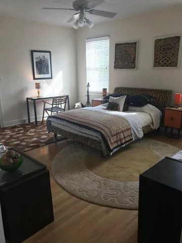a bedroom with a bed and wooden floor
