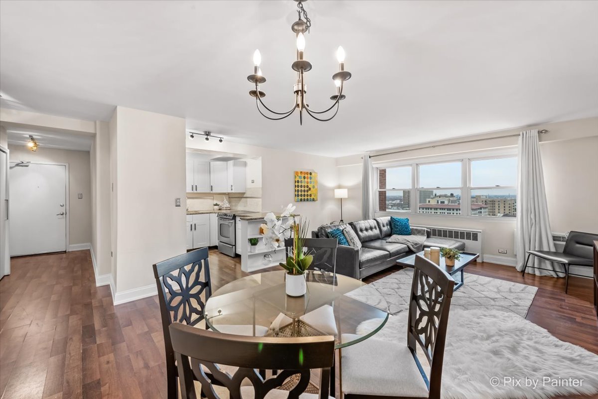 2909 North Sheridan Road, Unit 1507 Chicago, IL 60657 - Photo 2 of 27 a view of a dining room with furniture window and wooden floor