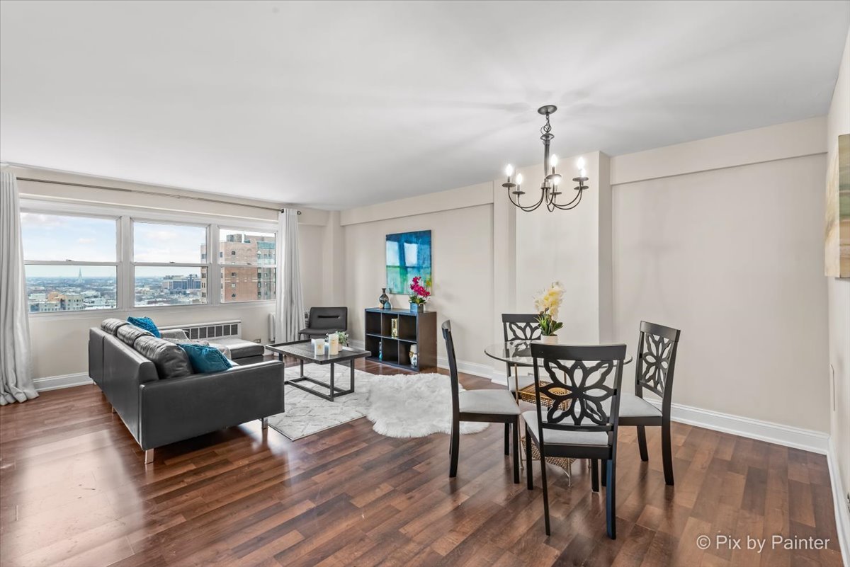 2909 North Sheridan Road, Unit 1507 Chicago, IL 60657 - Photo 3 of 27 a living room with furniture a chandelier and a dining table