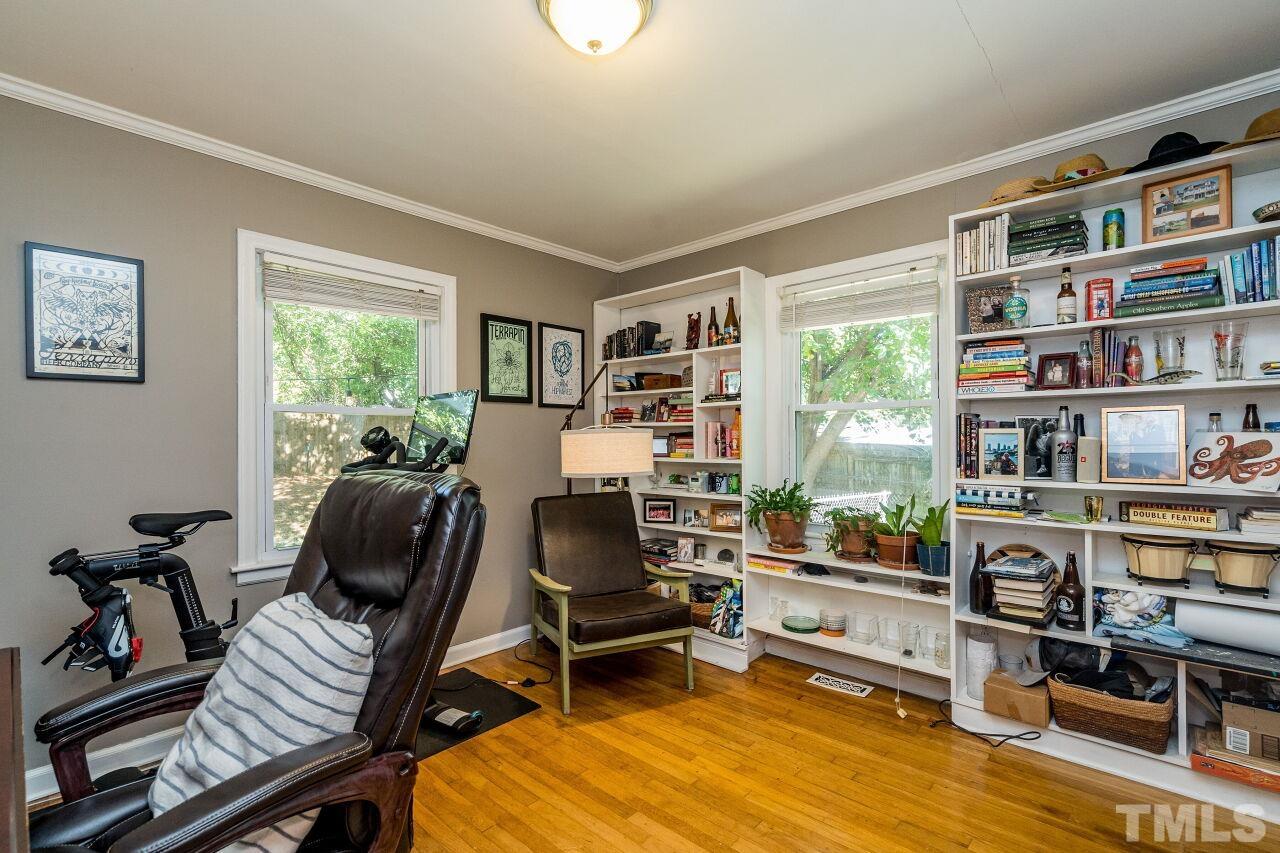 1113 North King Charles Road Raleigh, NC 27610 - Photo 16 of 24 a view of a workspace with furniture and a bookshelf