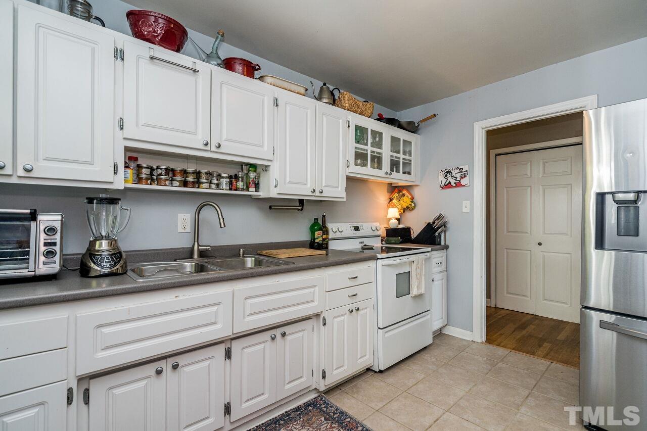 1113 North King Charles Road Raleigh, NC 27610 - Photo 10 of 24 a kitchen with granite countertop a sink and cabinets