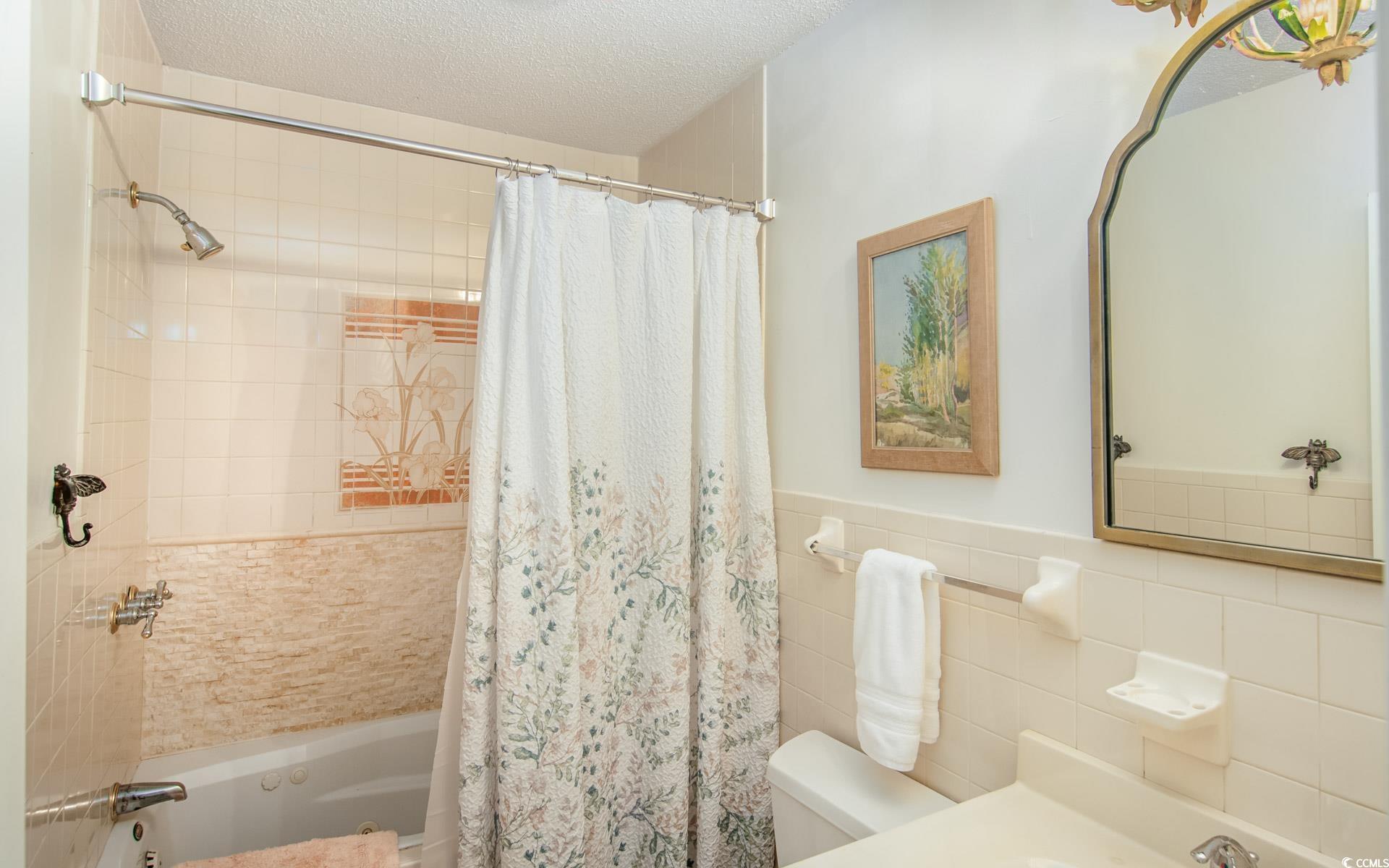 423 Highmarket Street Georgetown, SC 29440 - Photo 13 of 25 Full bathroom featuring tiled shower / bath combo, a textured ceiling, tile walls, and vanity