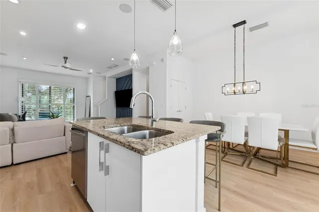 a kitchen with granite countertop a sink a counter top space and living room area