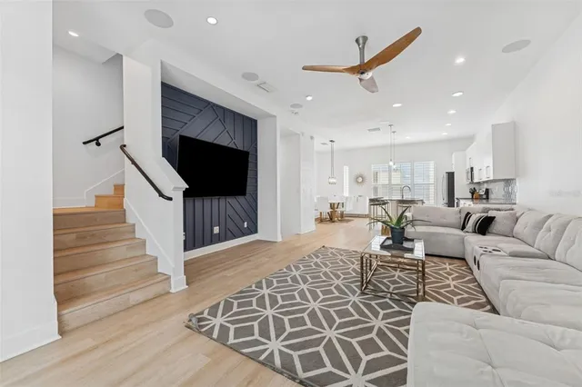 a living room with furniture a flat screen tv and kitchen view