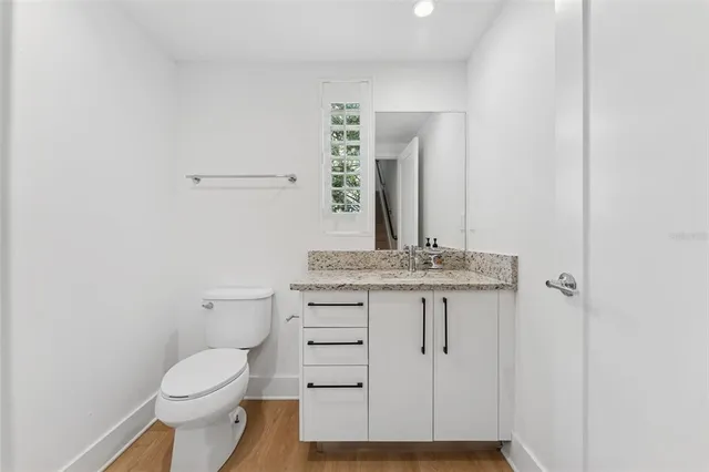 a bathroom with a granite countertop toilet sink and mirror