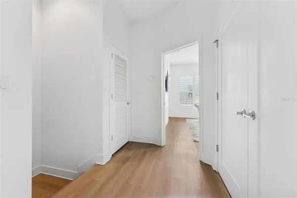 a view of a room with wooden floor and a bathroom