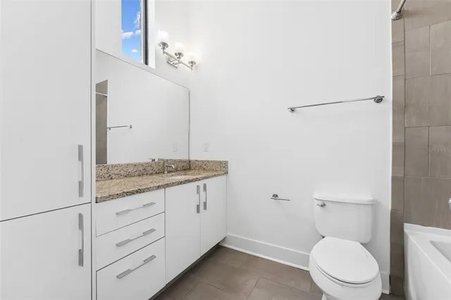 a bathroom with a white bath tub and a toilet