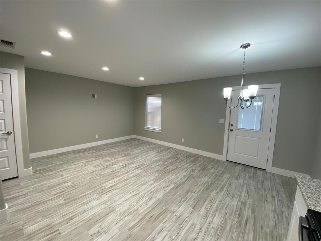 131 East Bond Street Denison, TX 75021 - Photo 2 of 10 a view of empty room with wooden floor and chandelier