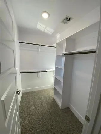 a view of walk in closet with empty racks