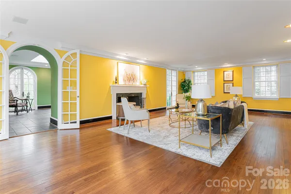 a living room with fireplace furniture and a large window