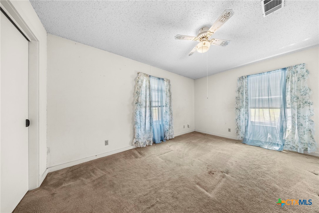 12558 Guyton Road Troy, TX 76579 - Photo 20 of 32 an empty room with chandelier fan and windows